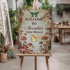 an easel with a welcome sign on it in front of some potted plants