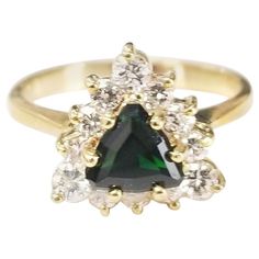 14k yellow gold tsavorite and diamond ring, containing 1 trillion cut tsavorite weighing .87pts. and 12 round full cut diamonds of very fine quality weighing .55pts. This ring is a size 6 but we will size to fit for free. Tsavorite is a trade name for the emerald-green variety of Grossular Garnet that originates in Africa. Tsavorite has become one of the most popular and expensive Garnets, due to its rarity combined with effective marketing tactics. This gemstone was first discovered in Tanzania Marketing Tactics, Cluster Ring, Tanzania, Emerald Green, Fashion Rings, Floral Rings, Garnet, Diamond Cuts, Diamond Ring