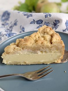 a piece of pie on a blue plate with a fork and napkin next to it