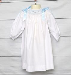 Baby Girl Dresses for Weddings Classic, oh yes! That's the word for our wedding dresses for kids. Our smocked dresses have a classic style with has perfect detailing and are perfect for a toddler girl wedding dress. White smocked baby clothes are perfect for any special occasion.  Zuli Kids offers smocked children's clothing that is perfect for those days at  the beach, summer get together and every special occasion for your precious baby girl. Baby girl dresses for weddings are long sleeves, They are white and smocked in blue with blue ribbons on the shoulder. Time tested and mother approved, smocked clothes are a must-have for little ones!        WHATS INCLUDED  One smocked dress.  RUSH ORDERS Smocked dresses ship in 1 to 2 business days. SHOP POLICIES All our items are custom made after Smocked Dresses For Toddlers, Flower Girl Dress Long Sleeve, Long Sleeve Flower Girl Dress, Get Together, Smocked Baby Girl Dresses, Smocked Baby Clothes, 1st Birthday Outfit Girl, Rustic Flower Girl