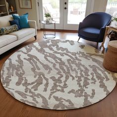 a living room with a large rug on the floor next to a couch and chair