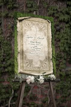 an old fashioned wedding sign in front of a wall covered with vines and ivys