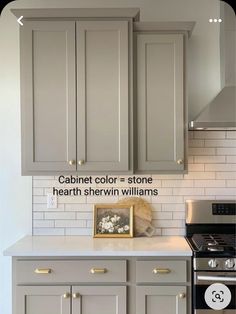 a kitchen with gray cabinets and white subway backsplash