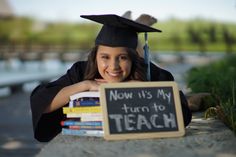 a girl in graduation cap and gown leaning on a sign that says now it's my turn to teach