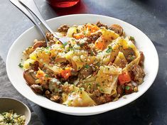 a white bowl filled with pasta and meat