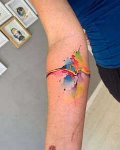 a woman's arm with a colorful tattoo on the left side of her arm