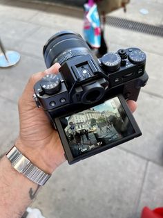 a person is holding up a camera to take a photo