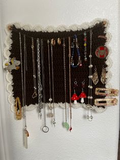 a white refrigerator freezer sitting next to a wall filled with necklaces and rings