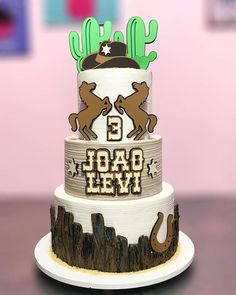 a three tiered cake with the number 3 on it's side and two deer decorations