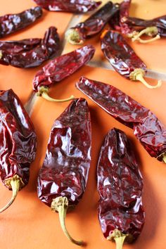 several red peppers on an orange counter top