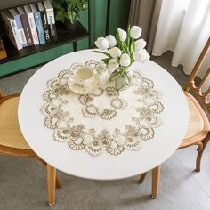 a white table topped with a vase filled with flowers