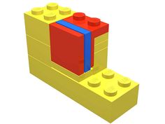 a yellow lego block with a blue ribbon on it's side and a red book in the middle