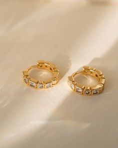 Add a touch of charm and sophistication to your jewelry collection with our Rae Geometric Huggies! Featuring sparkling cubic zirconia and shimmering gold, these earrings are perfect for adding a touch of elegance to any outfit. Elevate your style and embrace your unique beauty with these stunning huggies! EARRINGS FEATURE Material: Brass, White Cubic Zirconia Size: 14mm Finish: 18K Gold Freshwater Pearls Earrings, Unique Beauty, Pretty Earrings, Moonstone Ring, Opal Necklace, Delicate Necklace, Jewelry Packaging, Silver Roses, Silver Rose Gold