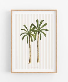 two palm trees in front of a white wall with vertical striped pattern on it, framed in wood frame