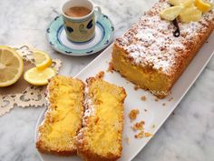 two slices of lemon cake on a plate next to a cup and saucer