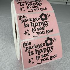 two rolls of pink and black stickers with words on them that say package is happy