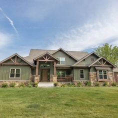 a large house sitting in the middle of a lush green field on a sunny day