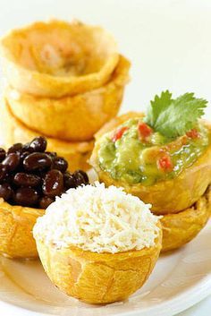 an assortment of food items on a plate with other foods in the bowl behind it