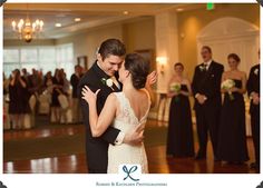 a bride and groom share their first dance at the wedding reception in front of an audience