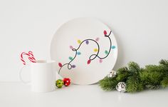 a white plate sitting on top of a table next to a cup and candy cane