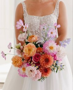 a woman holding a bouquet of flowers in her hands