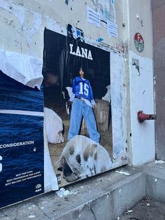 an advertisement on the side of a building with a man standing next to a pig