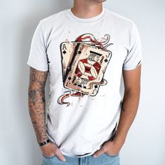 Elevate your casual style with our Poker Cards Unisex T-Shirt. Inspired by the timeless allure of the game, this tee features a captivating design showcasing intricately illustrated poker cards. Made from high-quality cotton, this t-shirt offers exceptional comfort and durability. The versatile unisex fit makes it suitable for all genders, while the classic crew neck and short sleeves add a touch of timeless appeal. Whether you're a poker enthusiast or simply appreciate the artistry of playing cards, this t-shirt is a stylish way to express your passion. Stand out from the crowd and showcase your love for the game with this unique and eye-catching tee. Graphic Print Crew Neck T-shirt For Gaming Events, Fan Merchandise Sublimation Print Short Sleeve Shirt, Fan Apparel Shirt With Sublimation Print And Crew Neck, Fan Merchandise Graphic Design Short Sleeve Shirt, Crew Neck T-shirt With Graphic Print For Gaming Events, White Gamer T-shirt With Graphic Print, Short Sleeve Graphic Design Fan Apparel Tops, Short Sleeve Graphic Fan Apparel Tops, White Gamer Graphic Print T-shirt