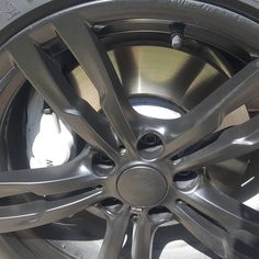 the front wheel of a car with black spokes