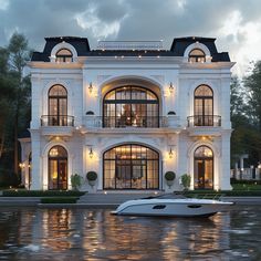 a boat is in front of a large white house with windows and balconies