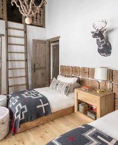 a bed room with two beds and a wooden ladder hanging from the wall above it