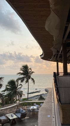 an ocean view from the balcony of a hotel room at sunset with palm trees in the foreground