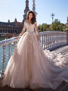 a woman in a wedding dress standing on a bridge