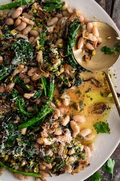 a white plate topped with beans and greens