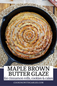 maple brown butter glaze in a cast iron skillet with cinnamon rolls on top