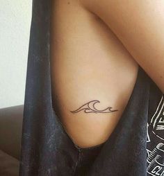 a woman's arm with a tattoo on it that has a wave in the middle