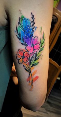 a colorful flower tattoo on the arm