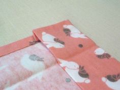 two pieces of fabric sitting next to each other on top of a table with scissors