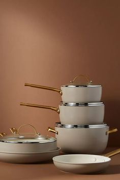 a stack of pots and pans sitting on top of a table next to each other