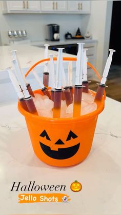 an orange bucket filled with lots of toothbrushes on top of a white counter