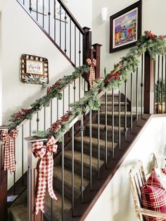 christmas decorations on the banisters and stairs are decorated with red and white plaid ribbon