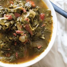 a white bowl filled with meat and greens