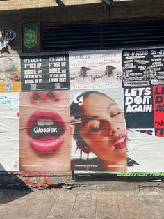 several posters on the side of a building with woman's lips painted on them