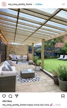 an outdoor living area with couches, chairs and a pergolated roof over it