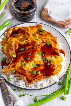 an enchilada on top of rice and green onions