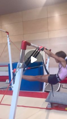 a woman is doing an aerial exercise on a gym equipment in the middle of a room