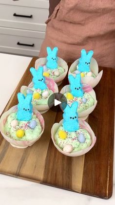 some little blue bunnies sitting on top of a wooden tray