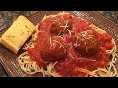 spaghetti and meatballs on a plate with bread