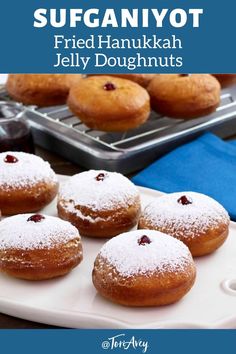 there are many doughnuts on the tray and one is covered in powdered sugar