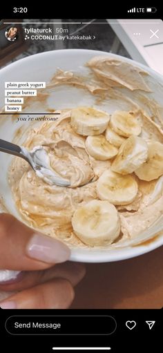 a person is holding a bowl of peanut butter and banana slices with a spoon in it