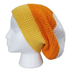 a white mannequin head with an orange and yellow knitted hat on it